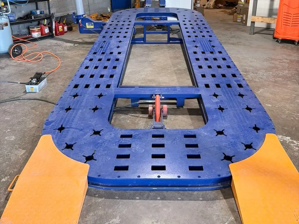 Blue frame straightening bench in the shop bay before a vehicle goes on