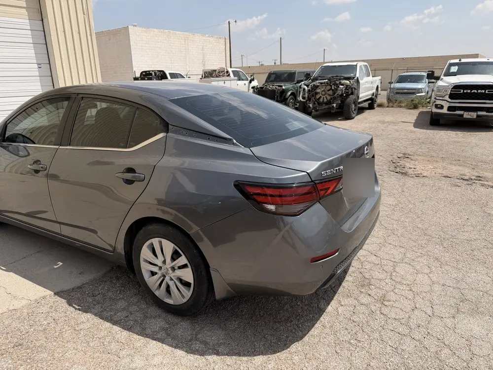 Same gray sedan with its rear quarter panel and bumper repaired and refinished