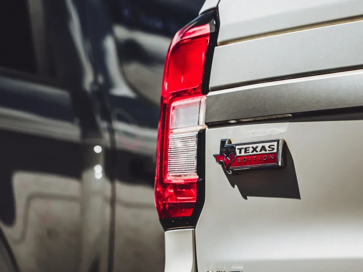 Rear taillight and badge of a white SUV after repair at the shop