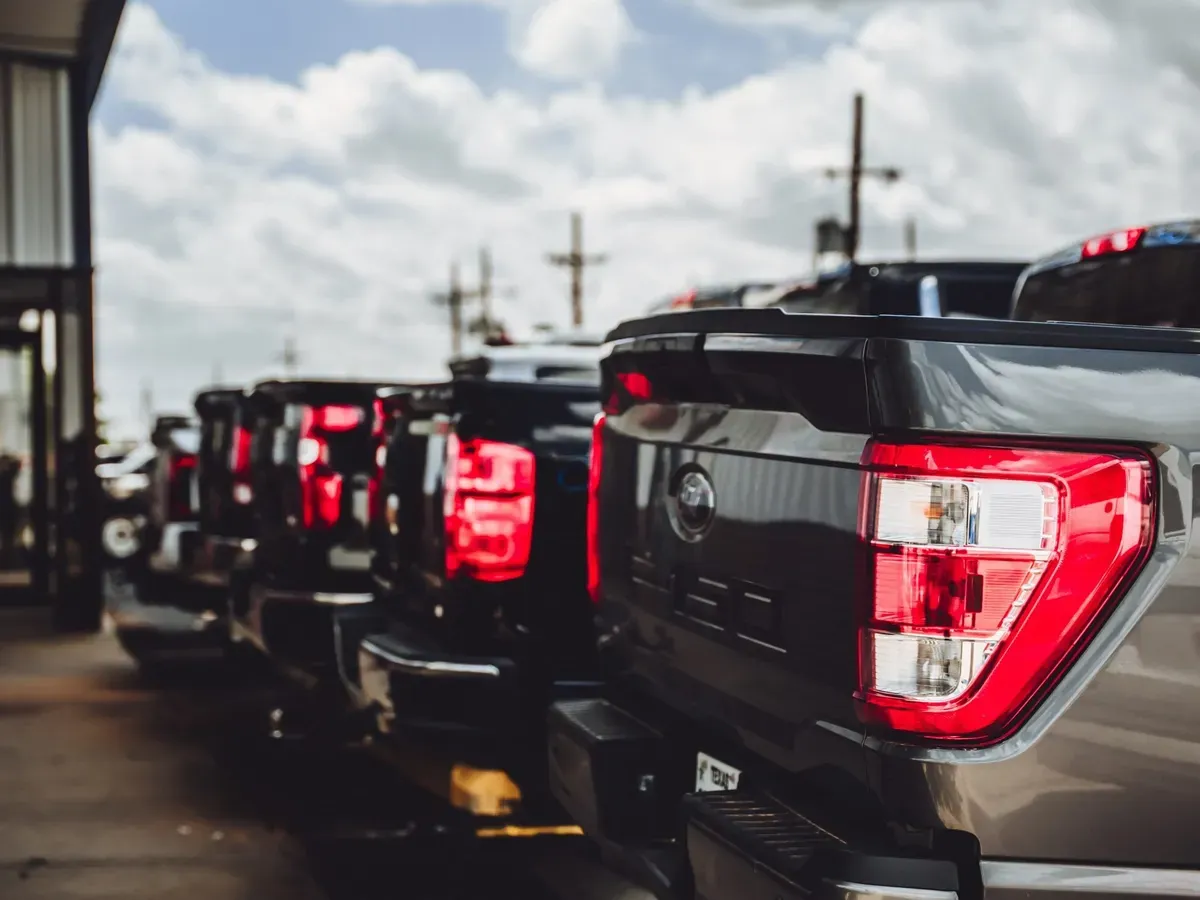 Row of pickup trucks lined up outside the shop waiting for repair